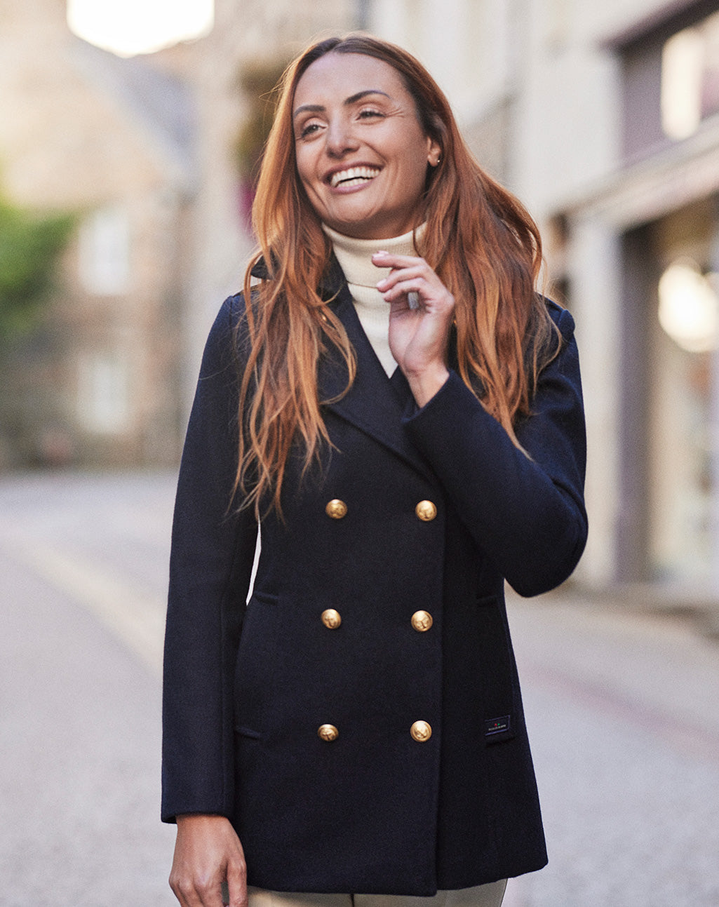 Vrouw draagt de donkerblauwe Detroit damescaban tijdens een wandeling, wat de elegante pasvorm benadrukt.