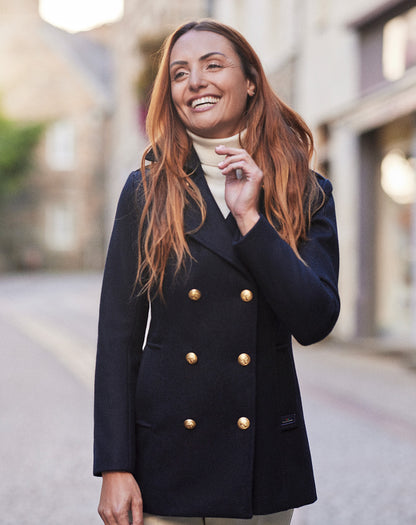 Vrouw draagt de donkerblauwe Detroit damescaban tijdens een wandeling, wat de elegante pasvorm benadrukt.