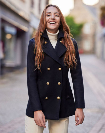 Vrouw draagt de donkerblauwe Detroit damescaban tijdens een wandeling, wat de elegante pasvorm benadrukt.